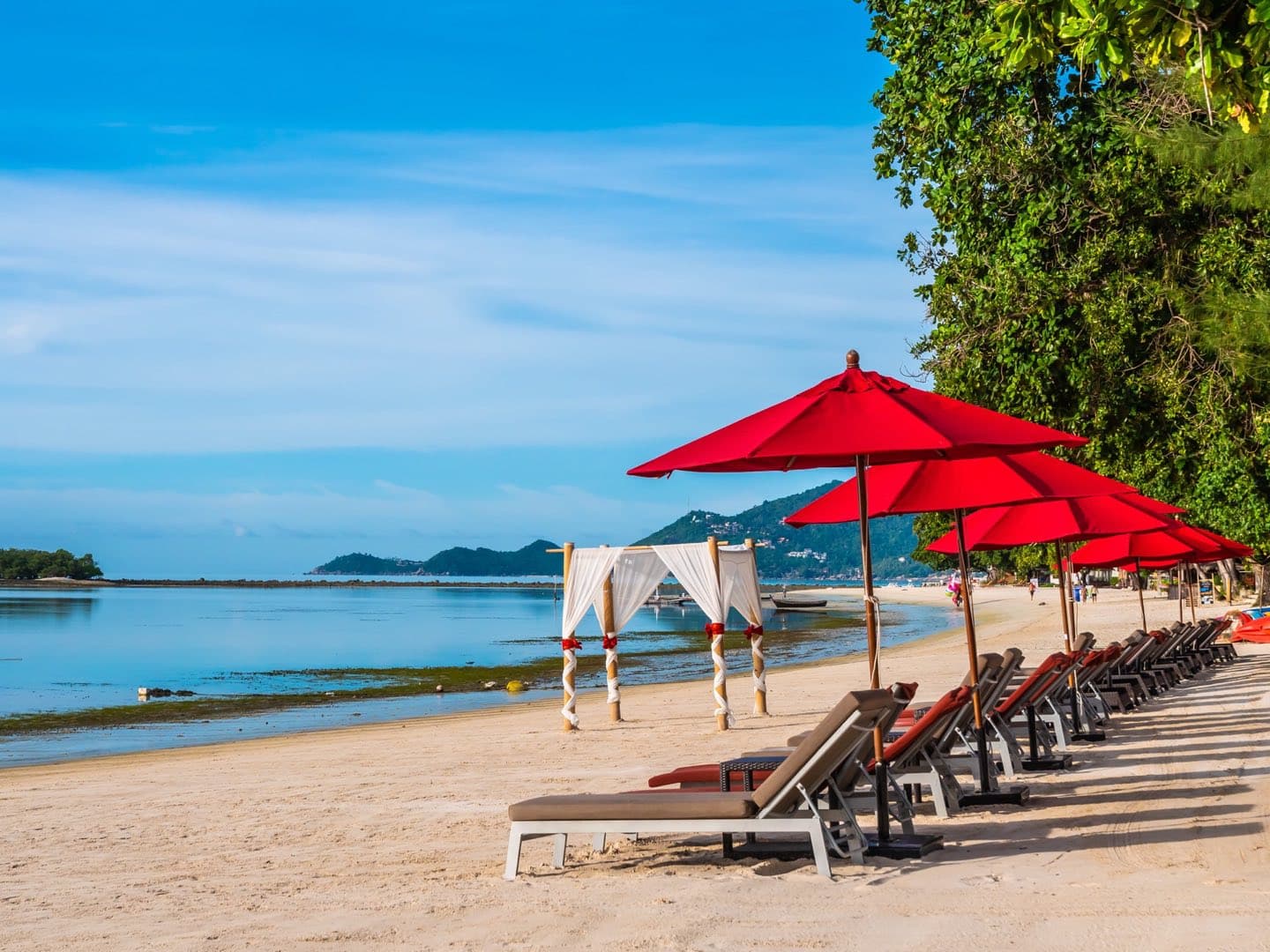 Kursi santai di tepi pantai dengan pemandangan laut biru — destinasi weekend getaway pantai dari Jakarta